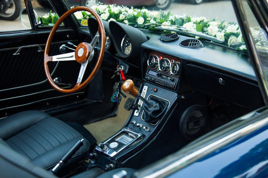The interior of a classic car adorned with colorful flowers creating a vibrant and nostalgic atmosphere