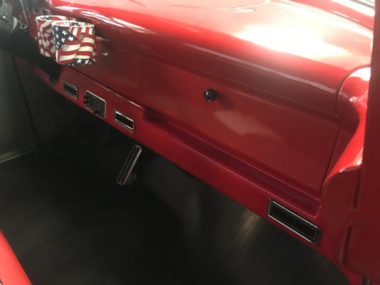 A red under dash extension panel of a 1956 Ford truck with a visible American flag emblem.