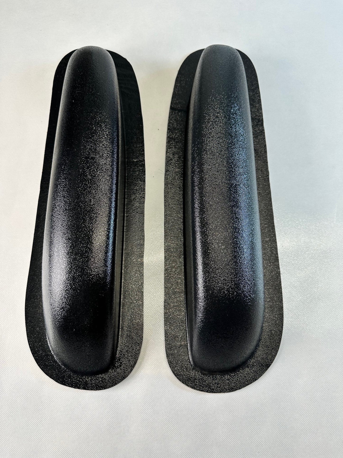 Two black rubber door seals on a white background