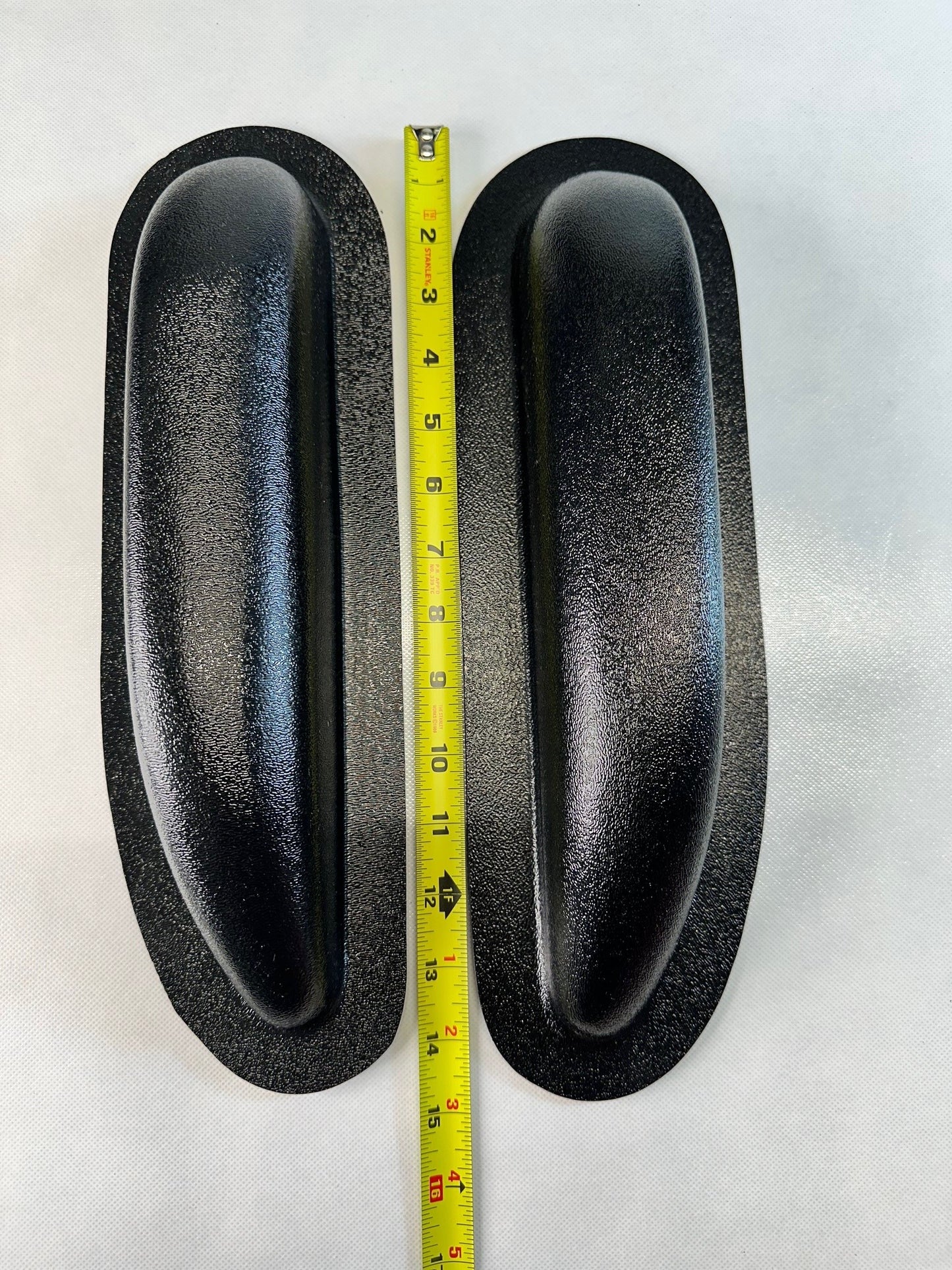 Two black rubber seals with a measuring tape between them on a white background