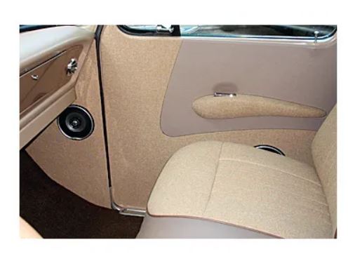 Beige interior of a car with door handle and speaker.