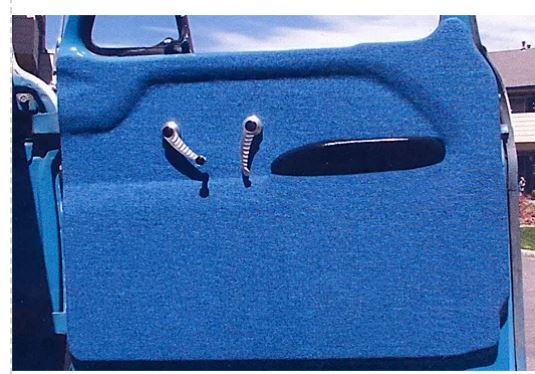 Close-up of a blue vehicle door with handle and lock details.
