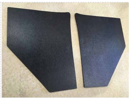 Two black car door panels on a beige textured background