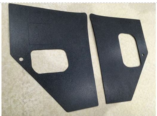 Two black car interior panels with cutouts on a beige background