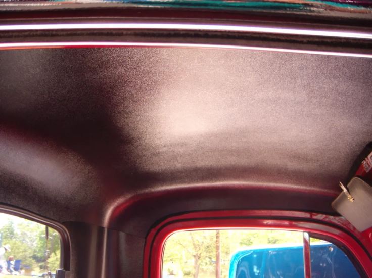Close-up of a car's interior ceiling with a metallic finish.