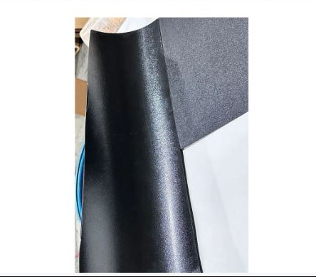 Roll of black and gray textured vinyl wrap on a plain background