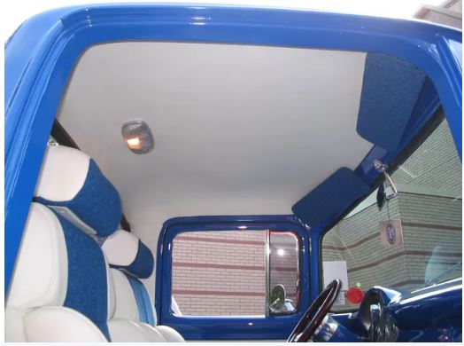 Interior view of a 1956 Ford truck showing the smooth blue headliner installed inside the cab above the seats.