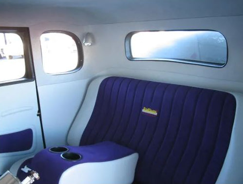 Interior of a vehicle with a purple seat and window design.