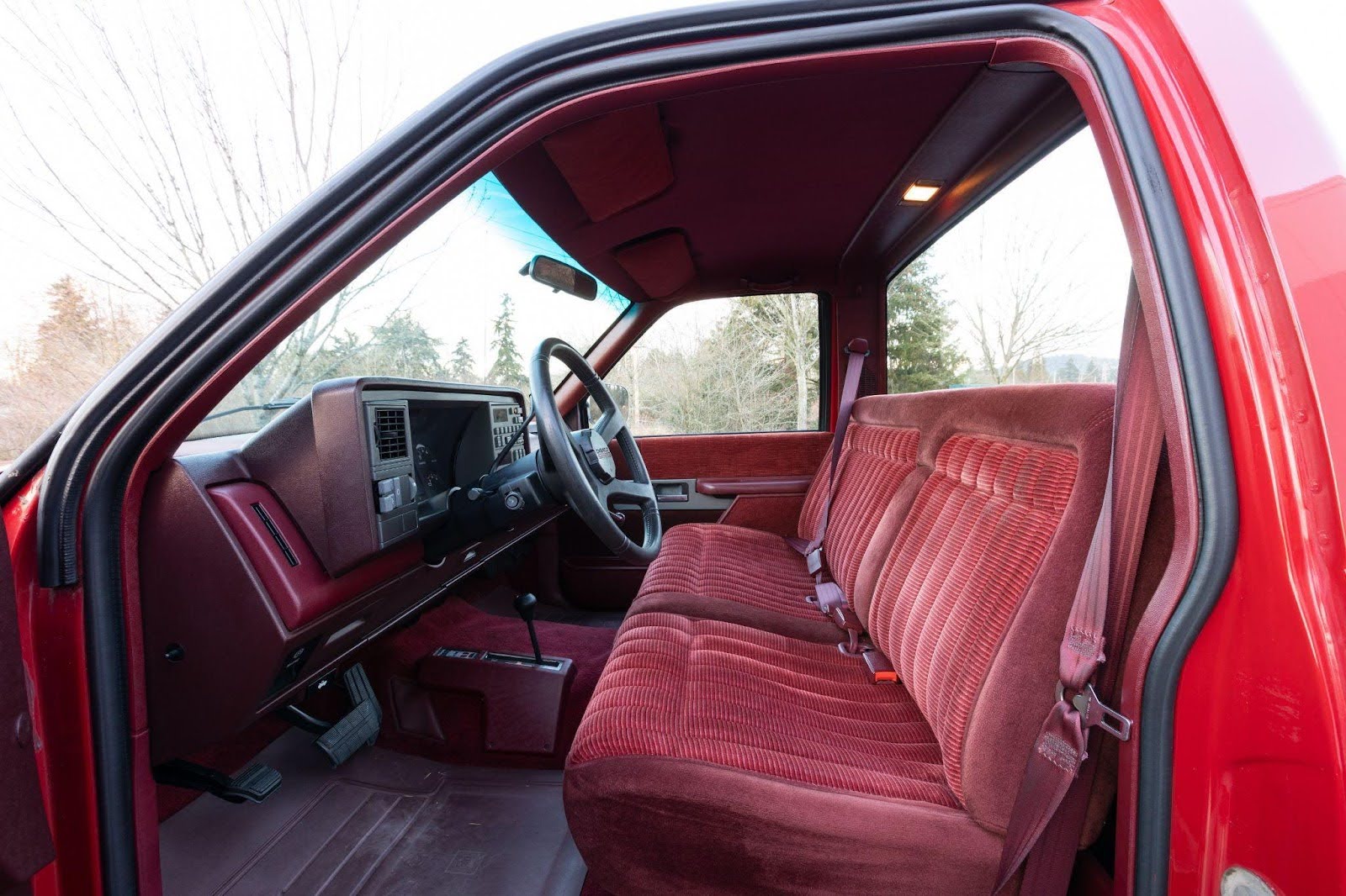 Interior view of a red truck showcasing the seats in an upright position