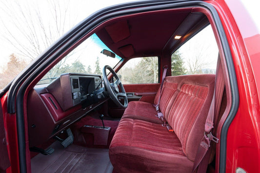 Interior view of a red truck showcasing the seats in an upright position