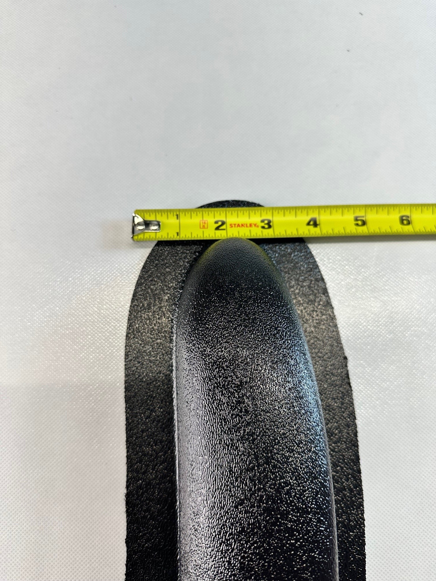 Close-up of universal modular ABS armrest top curve with measuring tape showing 2 inch protrusion depth