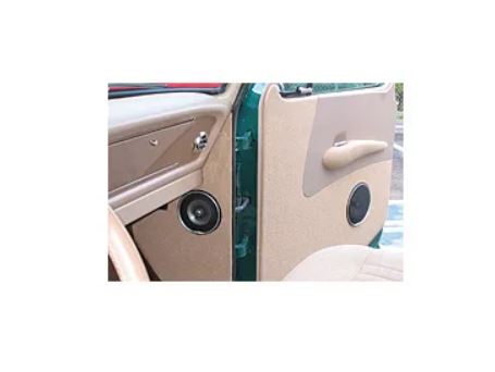 Tan vehicle door panel with modular armrest and speaker grille, alternate angle