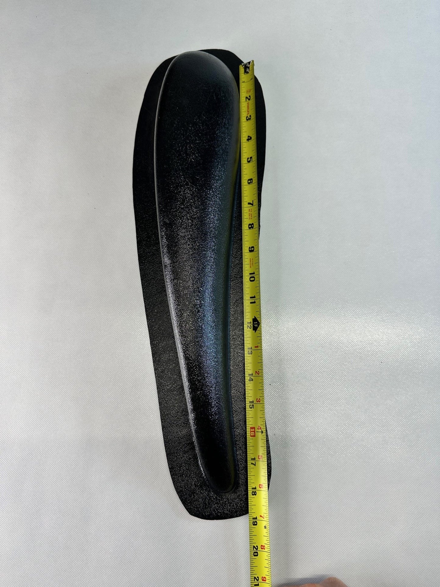 Single black ABS universal modular armrest shown with measuring tape indicating length