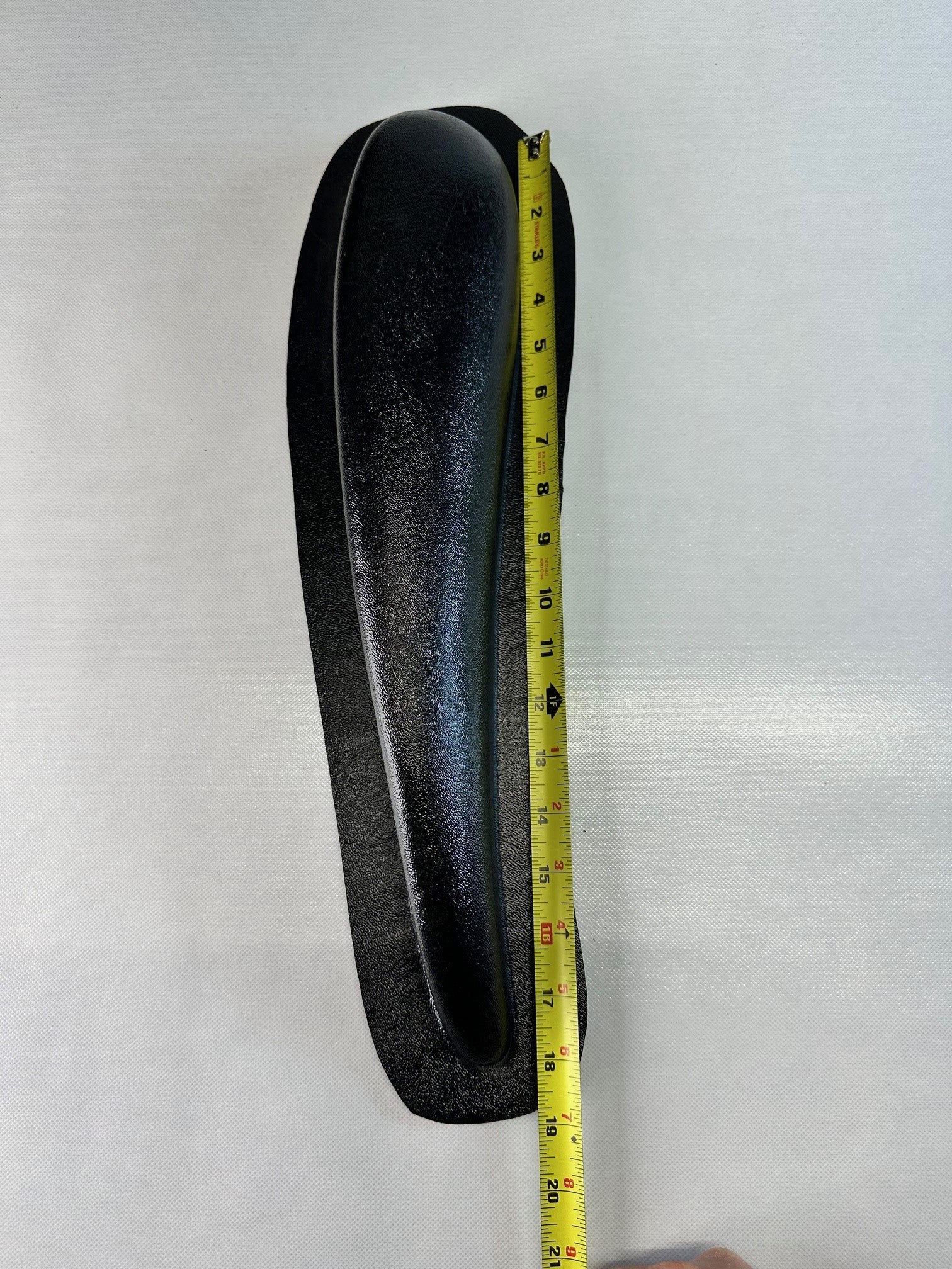 Single black ABS universal modular armrest shown with measuring tape indicating length