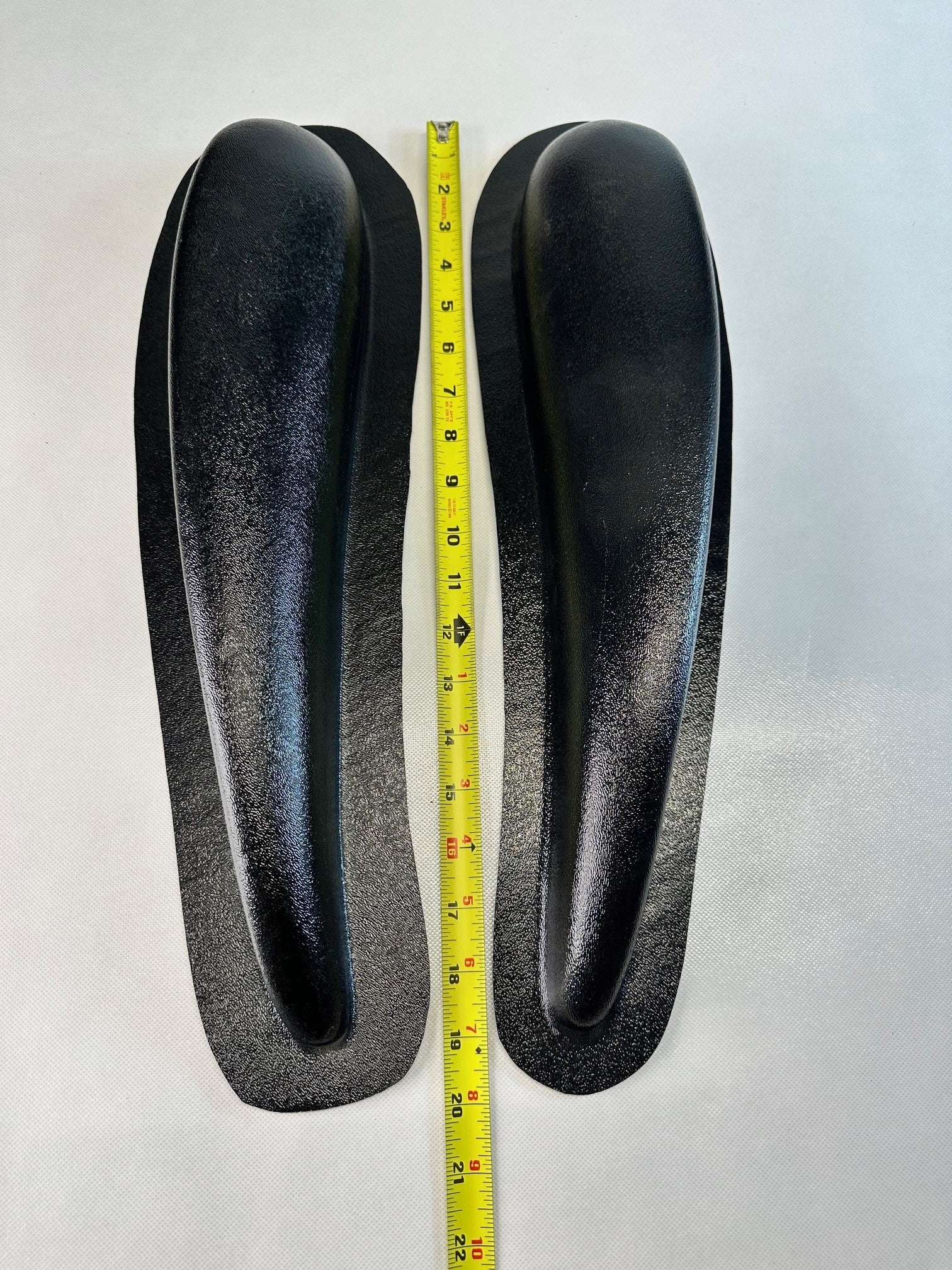 Pair of black ABS universal modular armrests shown with measuring tape indicating length