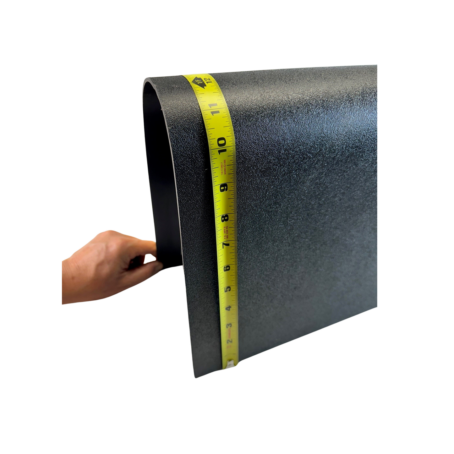 Roll of black matting with a yellow measuring tape on a white background