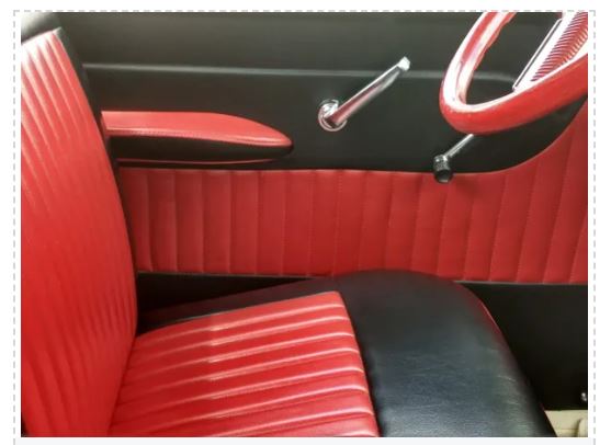 Close-up of a car's red and black interior, focusing on the seat and door panel.