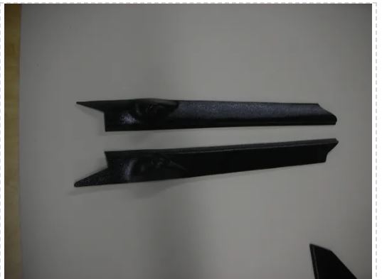 Two black car door sill protectors on a white background