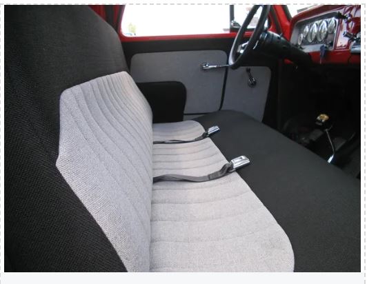 Interior view of a classic Chevrolet truck showing the front seat and kick panels.