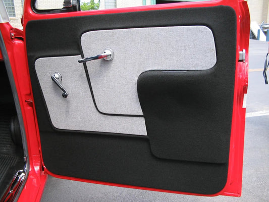 A photo showing a red Chevrolet truck door panel with a black and gray armrest area.
