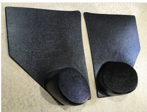 A pair of black kick panels for 1955-1959 Chevrolet trucks with speaker pods included.