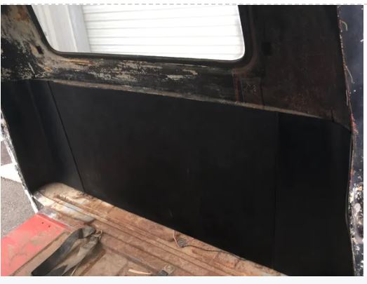 Black ABS rear cab cover and corner panels  installed in weathered 1955-1959 Chevrolet truck cab, rear window visible