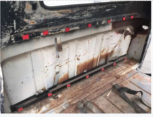 Rust and wear on the interior of a vehicle with visible rust patterns.
