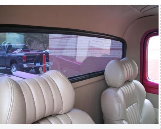 Beige car interior with a view of a parking lot through the window.