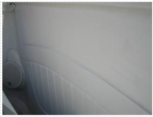 Close-up of a white car seat with visible wear and tear