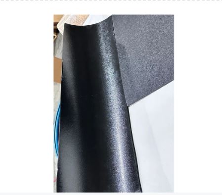 Roll of black and gray textured vinyl wrap on a plain background