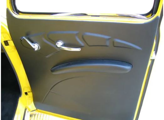 A black door panel for a 1947-1955 Chevrolet Sedan with an armrest, designed to replace the original stamped steel structure.