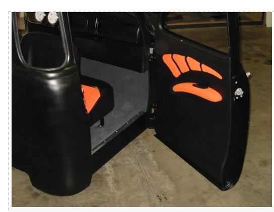 Car door open with orange hand design on a black interior