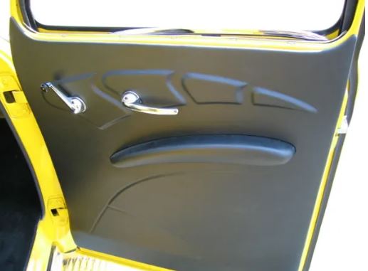 Close-up of a car door panel with a yellow exterior and gray interior.