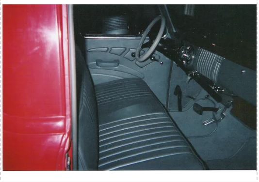 Close-up of a car interior with a red door panel.