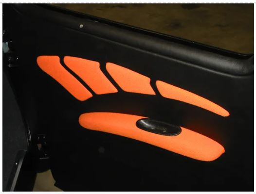 A pair of orange door panels with armrests designed for 1947-1955 Chevrolet Sedan models, displayed against a dark background.