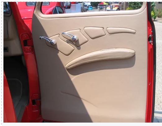 Beige car interior door panel with red car exterior visible