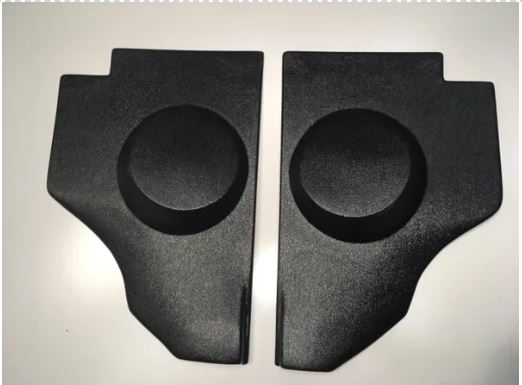 A pair of black kick panels with integrated speaker pods for a 1956 Ford truck.