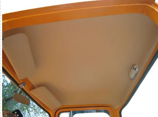 Close-up of a vehicle's open roof with beige interior and yellow exterior.
