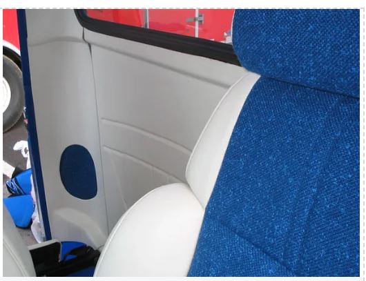 Close-up of a car interior with blue seat covers and a red exterior.
