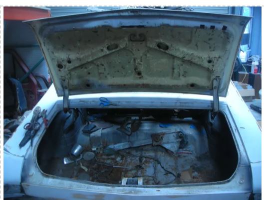 Open trunk of a car with visible engine components.