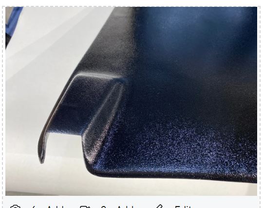 Close-up of a dark blue textured surface, possibly a car hood.
