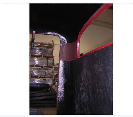 Black ABS rear cab cover corner detail near rear window opening, red pinstripe trim visible on Studebaker truck cab