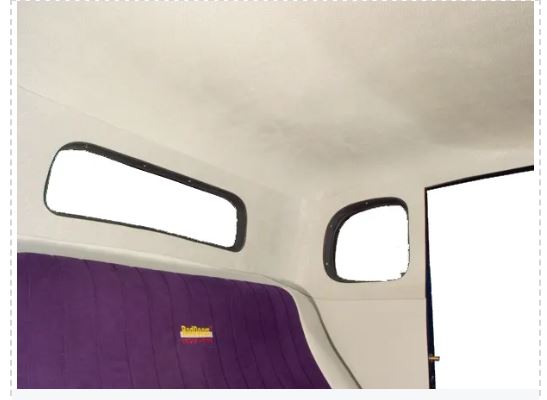 A photo showing a car headliner with quarter panels, primarily in a solid white color with a visible purple fabric detail.