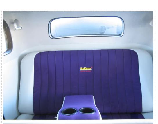 Car interior with purple headrest and cup holder.