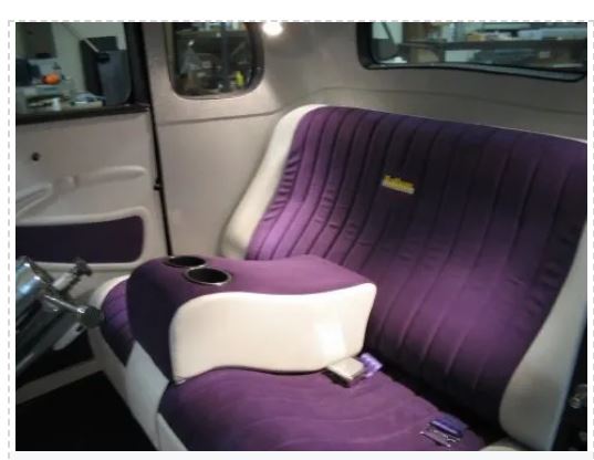 Purple and white car seat in a vehicle interior.