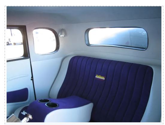 Interior of a vehicle with a purple seat and window design.