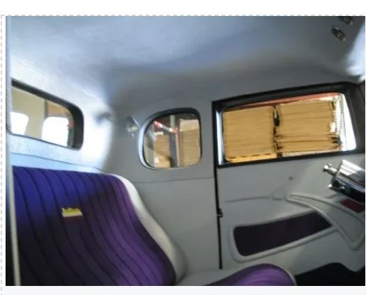Interior of a vehicle with purple seat and window reflections.