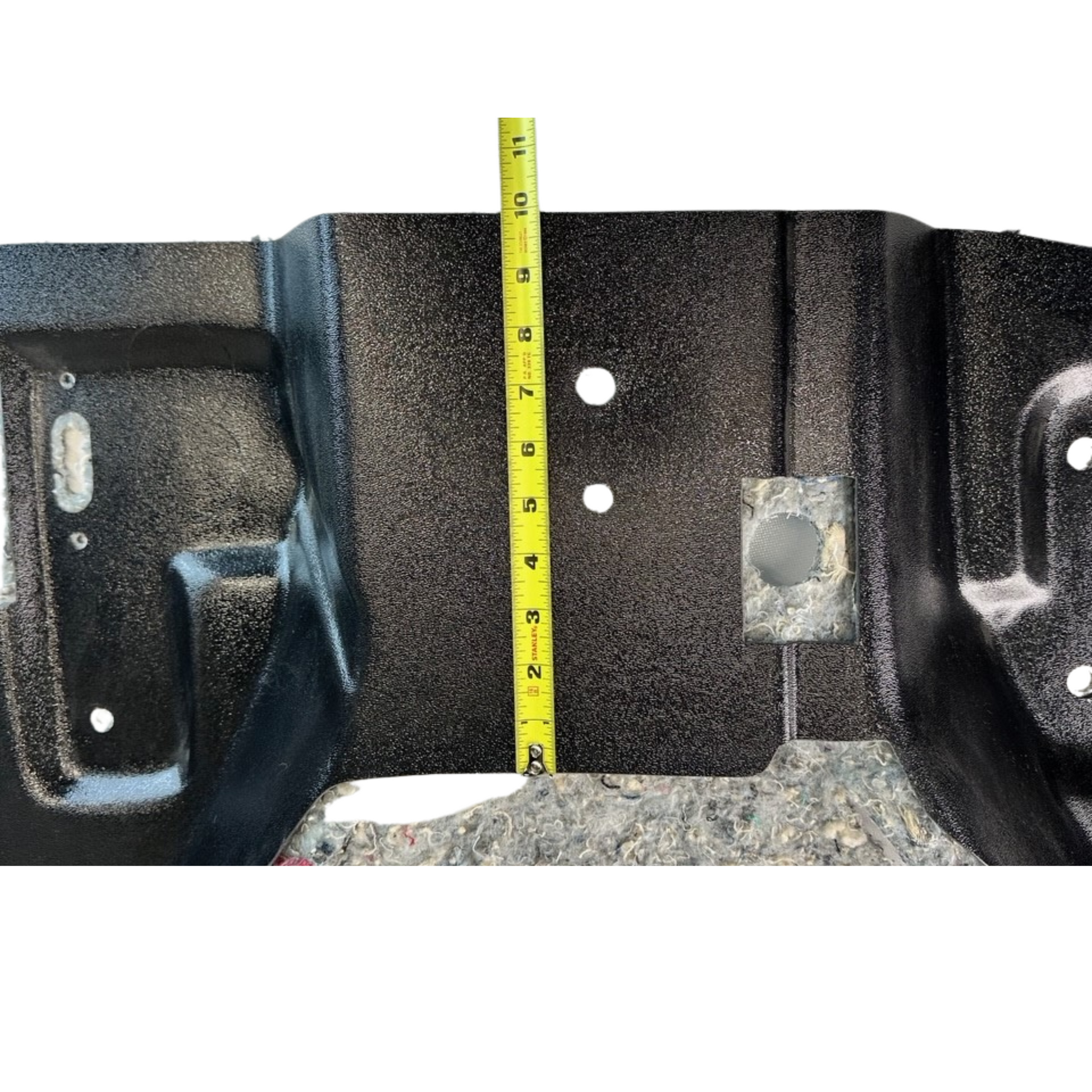 Black metal bracket with measurement tape showing dimensions on a concrete surface