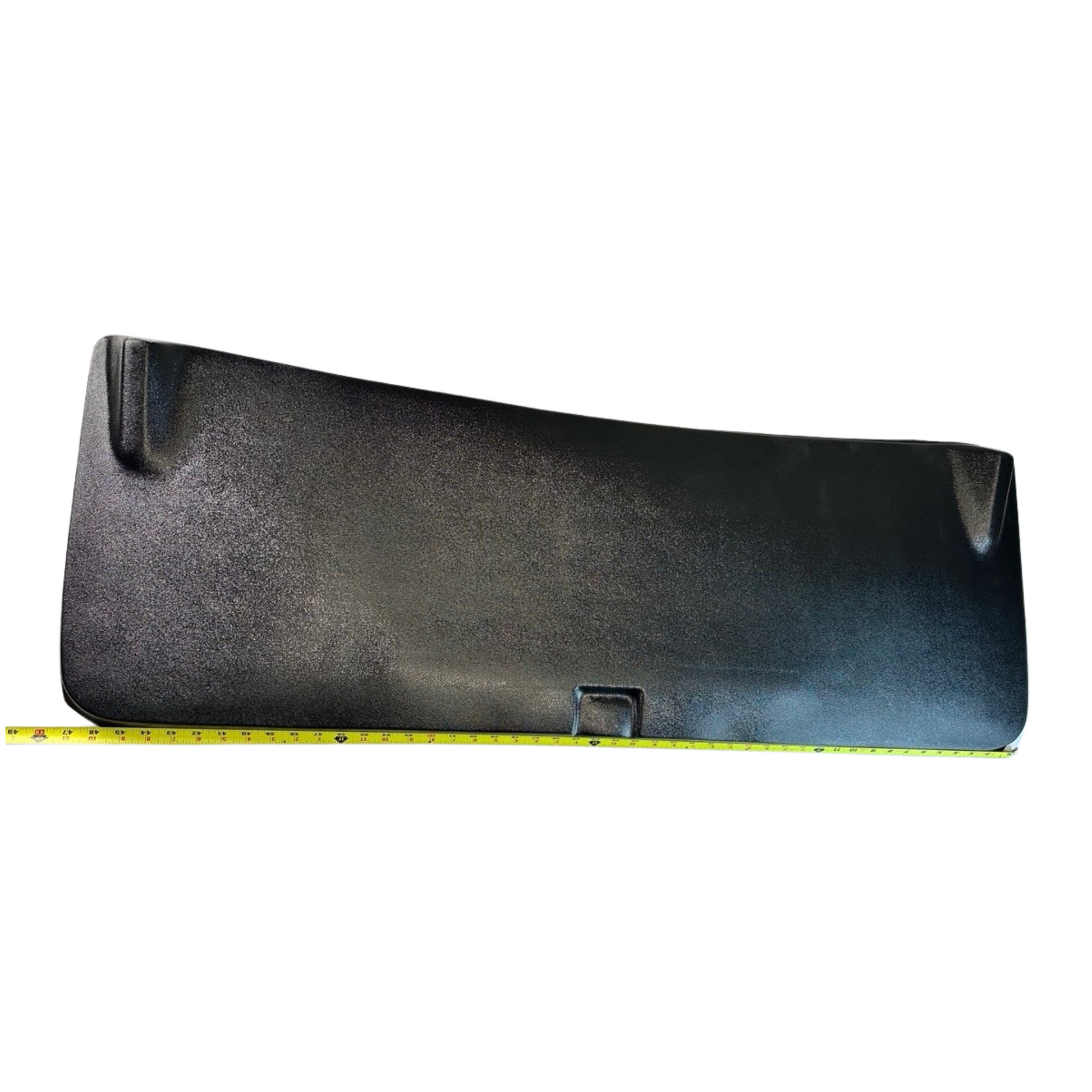 Black plastic cover with a measuring tape for scale on a white background
