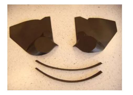 Two dark brown ear cups on a textured surface.